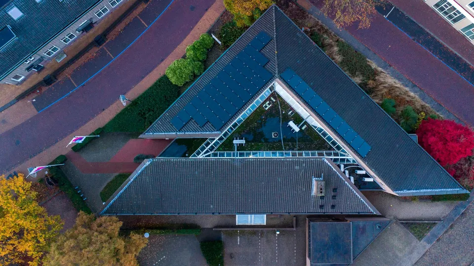 Woonwijk met zonnepanelen op het dak, van bovenaf
