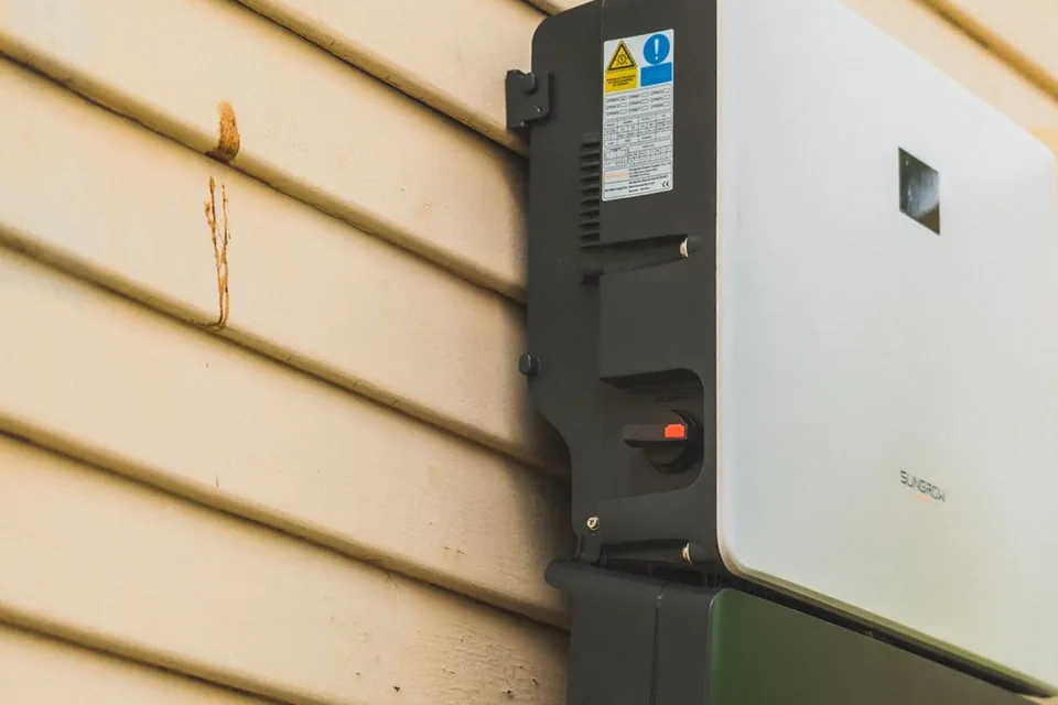 Thuisbatterij en omvormer aan een buitenmuur