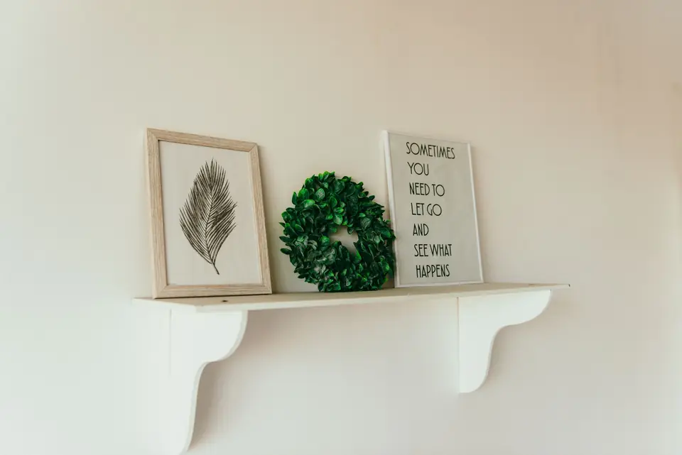 Wandplank met lijsten en planten