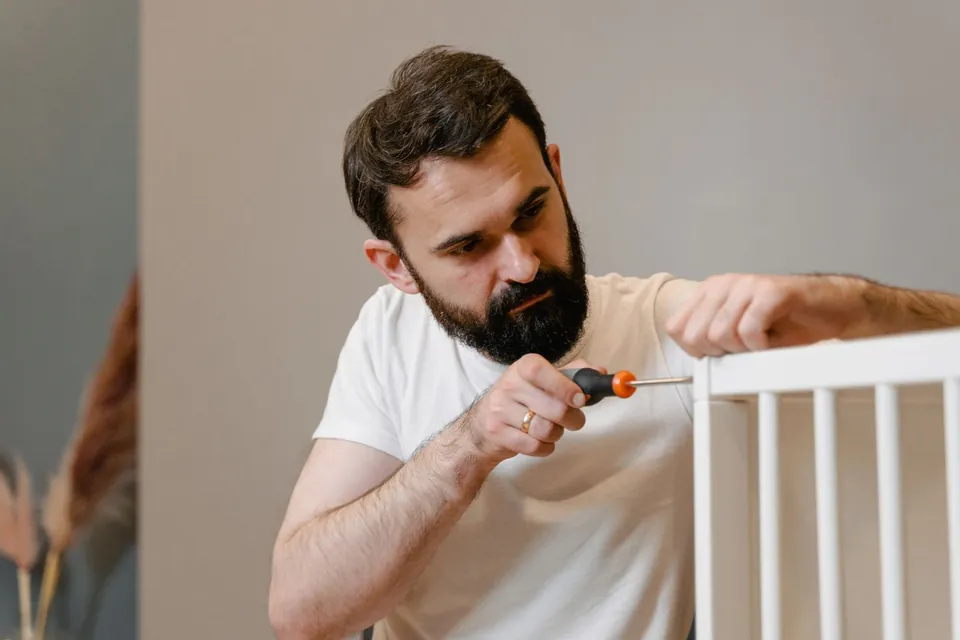 Vakman schroeft een meubel in elkaar in een lichte kamer