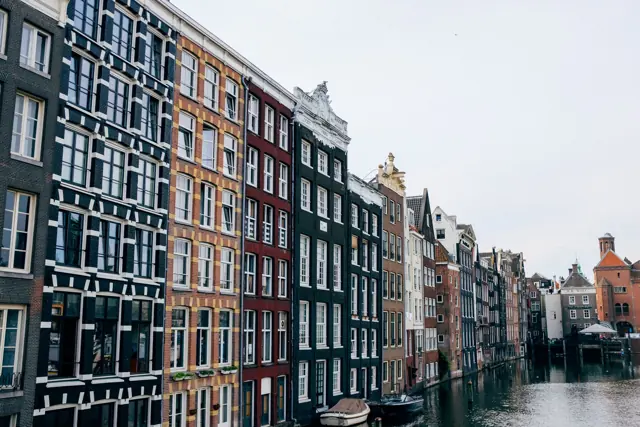Smalle grachtenpanden met verschillende gevels langs een gracht