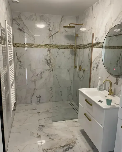 Badkamer in marmerlook met inloopdouche, goudkleurig kraanwerk en wastafelmeubel