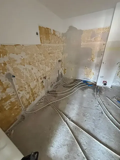 Gestripte badkamer met nieuw aangelegde leidingen in de vloer