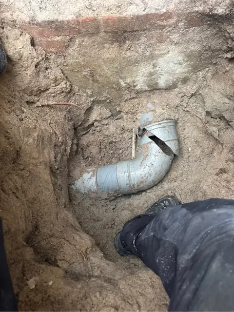 Nieuwe rioolbocht in een opengegraven kruipruimte