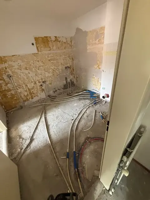 Gestripte badkamer met nieuwe leidingen naar de aansluitpunten