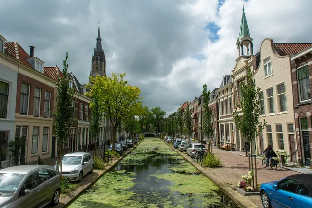 Gracht in de binnenstad van Delft met grachtenpanden en de Nieuwe Kerk