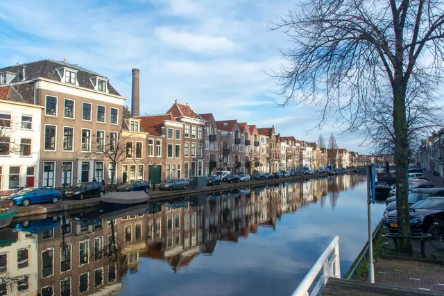 Gracht in Leiden met oude huizen die weerspiegelen in het water